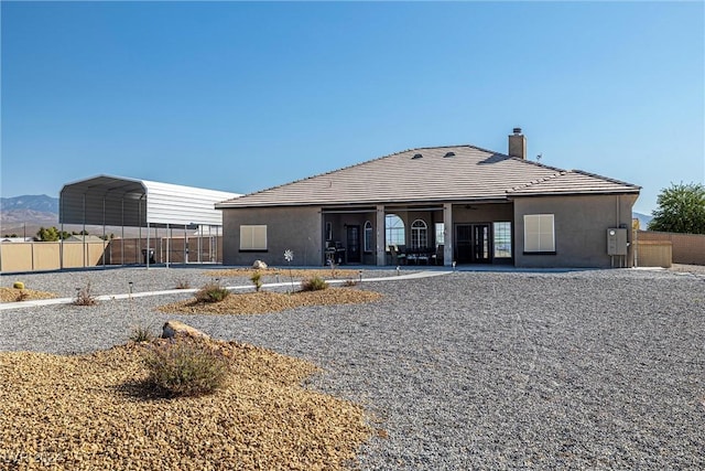 back of house with a mountain view and a carport