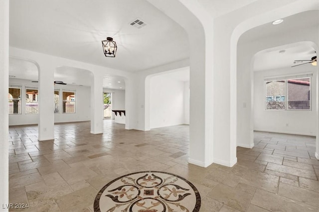 interior space featuring ceiling fan with notable chandelier and a healthy amount of sunlight