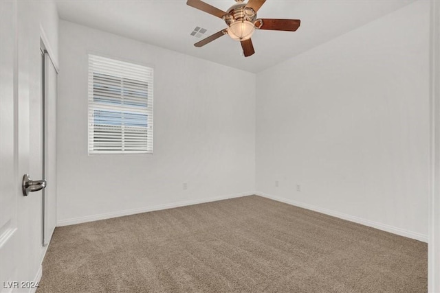 empty room with ceiling fan and light carpet