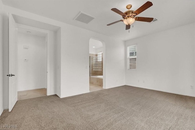 spare room with ceiling fan and light carpet