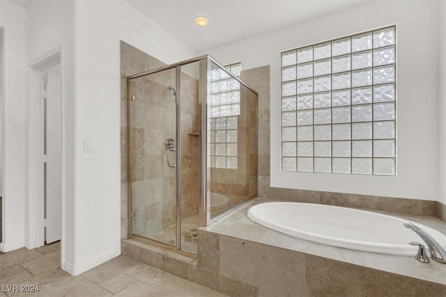 bathroom with tile patterned floors and shower with separate bathtub