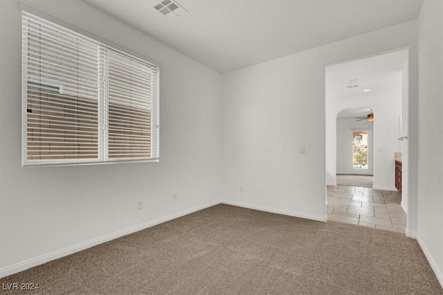 spare room featuring carpet flooring and ceiling fan