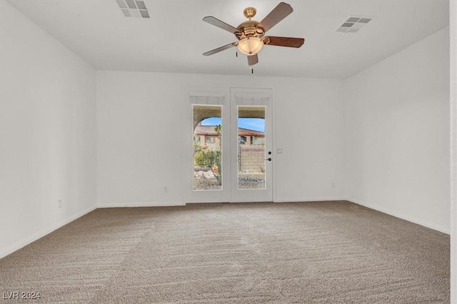 carpeted spare room featuring ceiling fan