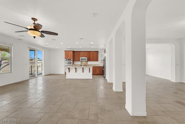 unfurnished living room featuring ceiling fan