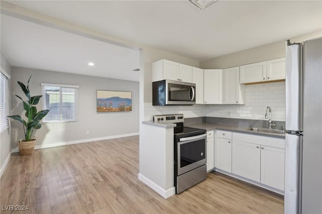 kitchen with sink, stainless steel appliances, backsplash, light hardwood / wood-style floors, and white cabinets