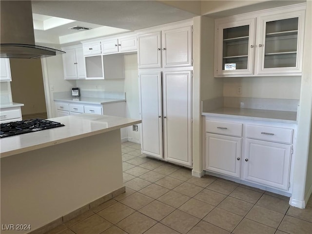 kitchen with white cabinetry, gas stovetop, visible vents, and island range hood