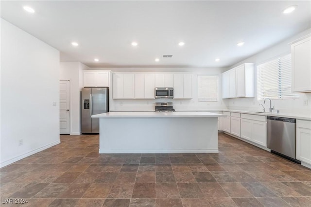 kitchen featuring a center island, white cabinetry, sink, and appliances with stainless steel finishes