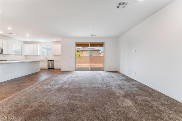 unfurnished living room with dark colored carpet