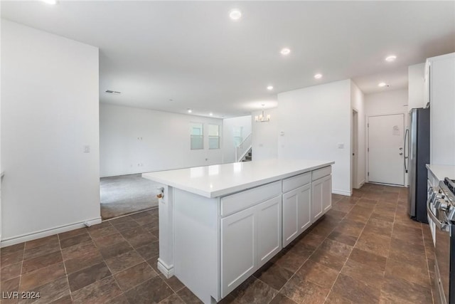 kitchen with a chandelier, a center island, white cabinets, and stainless steel appliances