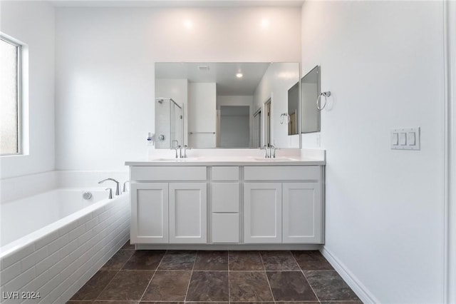 bathroom featuring a relaxing tiled tub and vanity