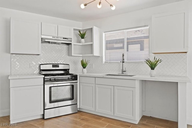 kitchen with gas stove, white cabinetry, sink, and light hardwood / wood-style flooring