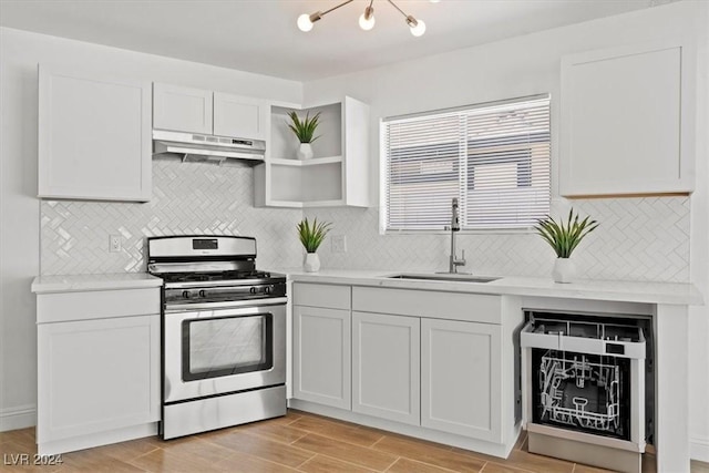 kitchen featuring decorative backsplash, stainless steel gas range, sink, light hardwood / wood-style flooring, and white cabinetry