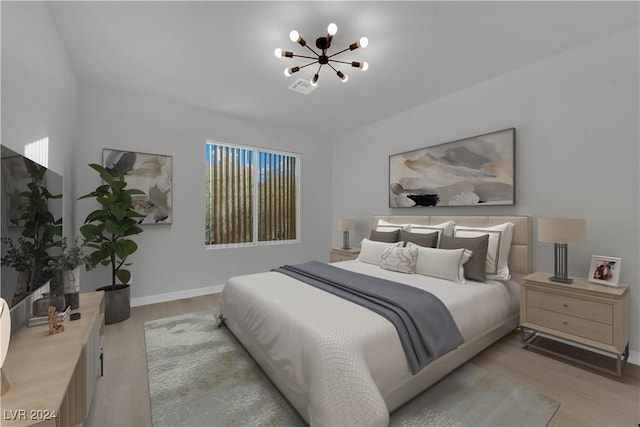 bedroom featuring a chandelier and light wood-type flooring