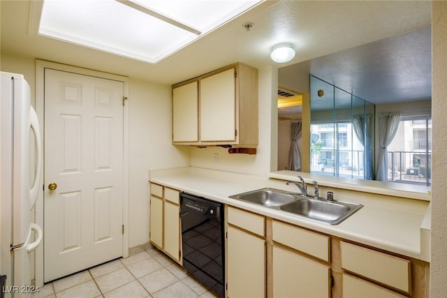 kitchen featuring sink, light tile patterned floors, black dishwasher, white refrigerator, and cream cabinets