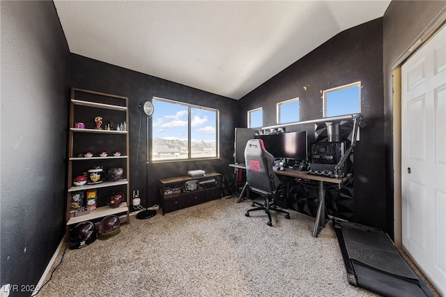 carpeted home office featuring lofted ceiling