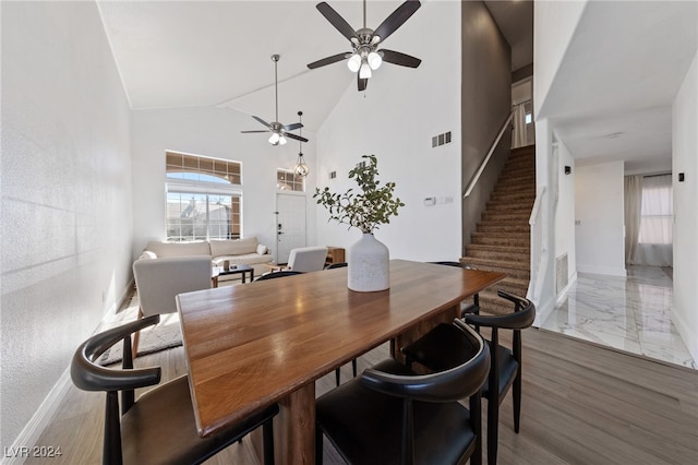 dining space with dark hardwood / wood-style flooring, vaulted ceiling, and ceiling fan