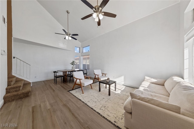 living room featuring ceiling fan, high vaulted ceiling, and light hardwood / wood-style floors