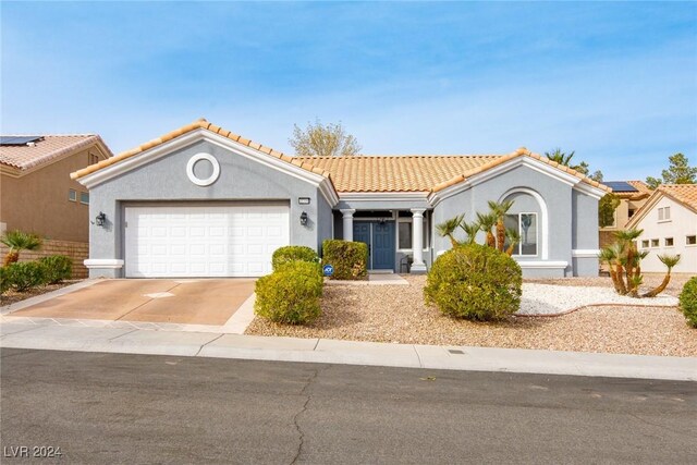 mediterranean / spanish home with a garage