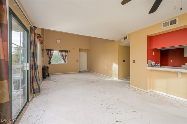 unfurnished living room featuring ceiling fan, a healthy amount of sunlight, and concrete flooring