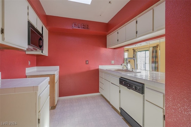 kitchen featuring dishwasher, white cabinetry, tile counters, and sink