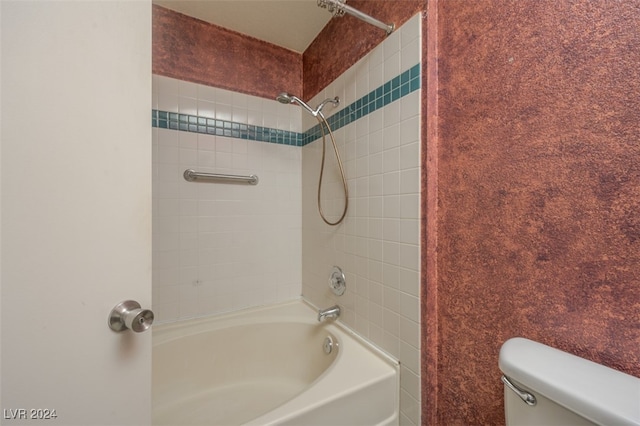 bathroom featuring tiled shower / bath and toilet