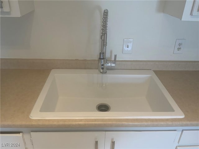 interior details with white cabinets and sink