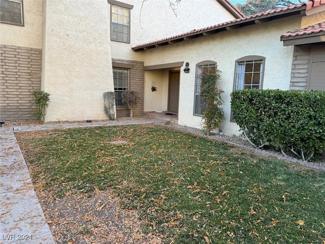 doorway to property with a lawn