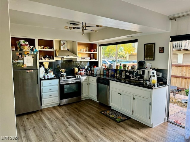 kitchen featuring white cabinets, stainless steel appliances, wall chimney range hood, and light hardwood / wood-style floors