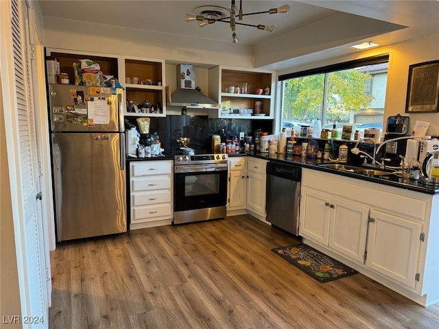 kitchen featuring white cabinetry, sink, stainless steel appliances, wall chimney range hood, and wood-type flooring