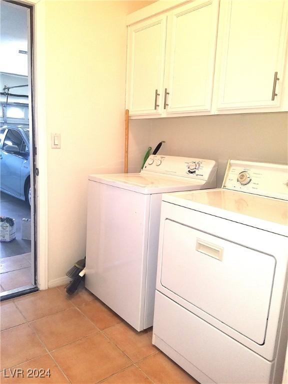 washroom featuring cabinets, independent washer and dryer, and light tile patterned floors