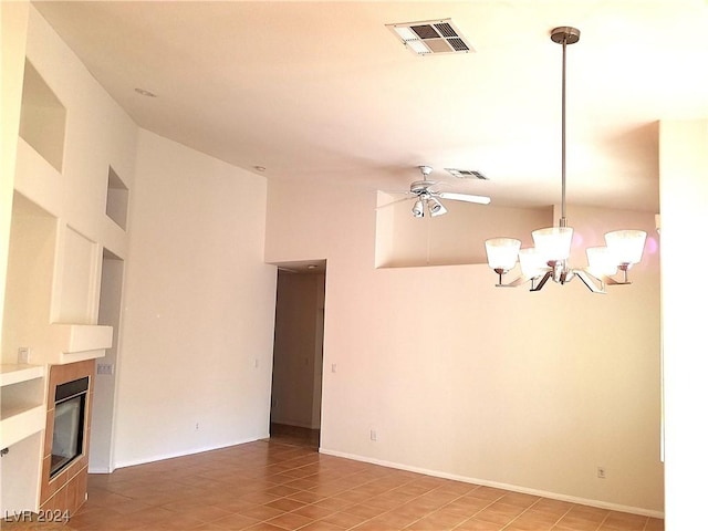 unfurnished living room featuring tile patterned flooring, a towering ceiling, and ceiling fan with notable chandelier