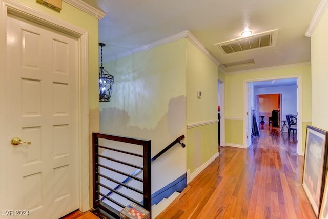 hallway with hardwood / wood-style flooring and crown molding