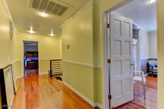 hall with hardwood / wood-style flooring and ornamental molding