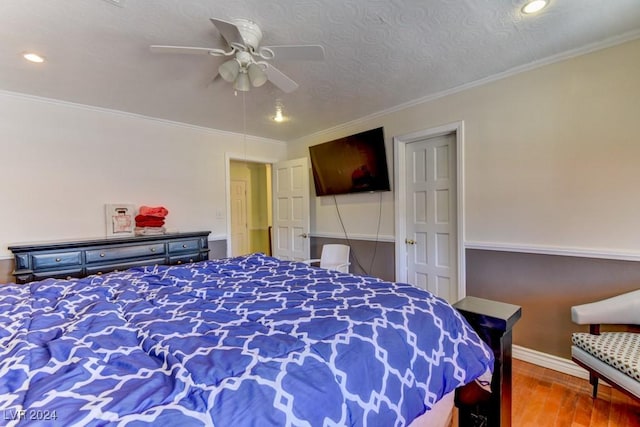 bedroom featuring hardwood / wood-style flooring, ceiling fan, and ornamental molding