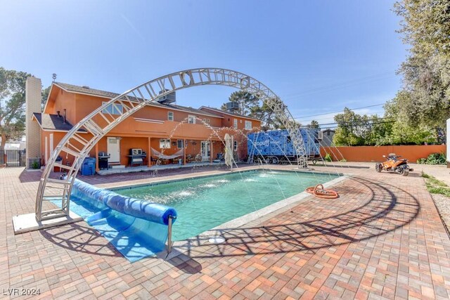 view of pool featuring pool water feature and a patio area