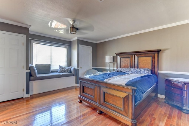 bedroom with crown molding, hardwood / wood-style flooring, and ceiling fan