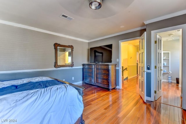 bedroom with crown molding and wood-type flooring