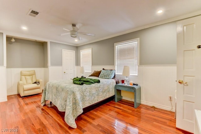 bedroom featuring ceiling fan, ornamental molding, and light wood-type flooring