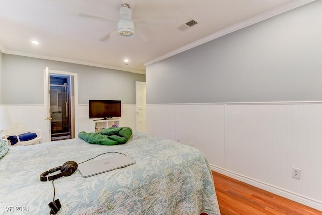 bedroom featuring crown molding, ensuite bath, light hardwood / wood-style floors, and ceiling fan