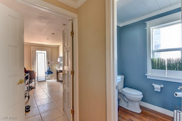 bathroom featuring tile patterned flooring, ornamental molding, and toilet