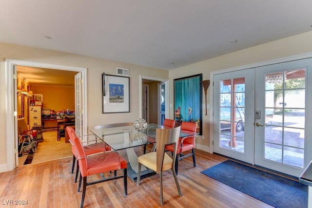 dining space with light hardwood / wood-style floors and french doors