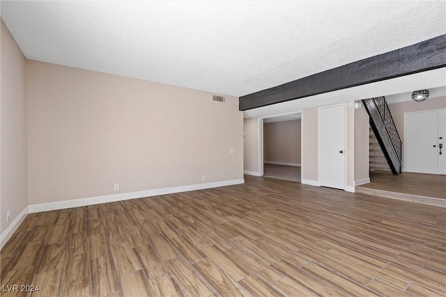 unfurnished room with hardwood / wood-style floors and a textured ceiling