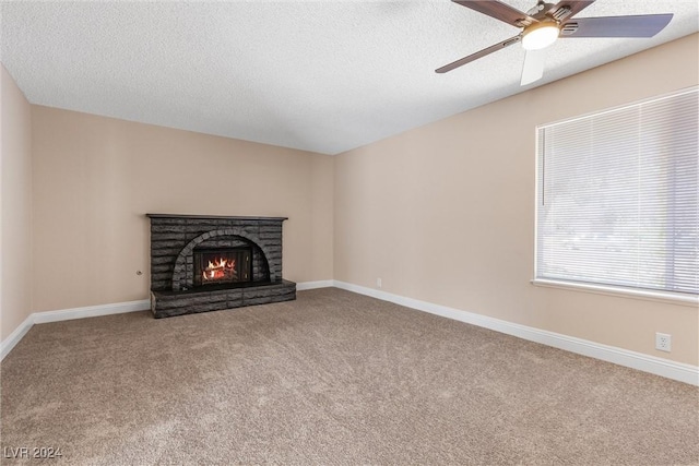 unfurnished living room with carpet floors, a textured ceiling, and a brick fireplace