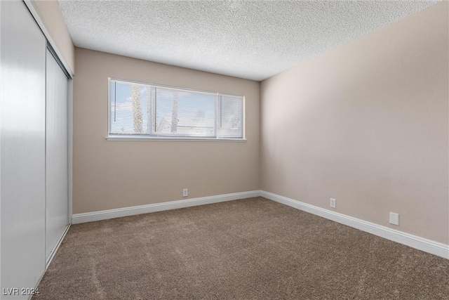 unfurnished bedroom featuring carpet flooring, a closet, and a textured ceiling