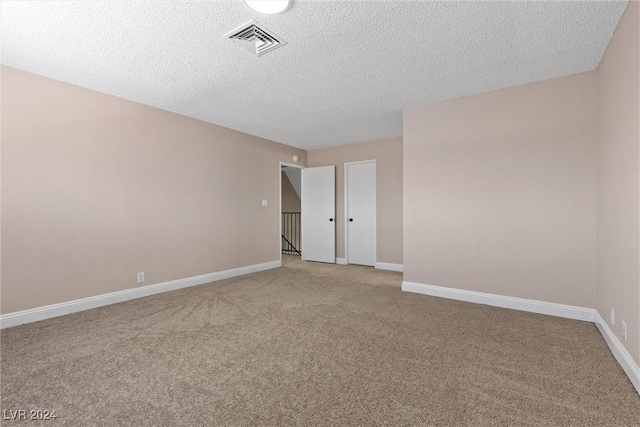 carpeted spare room featuring a textured ceiling