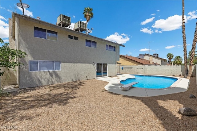 view of pool featuring a diving board and cooling unit