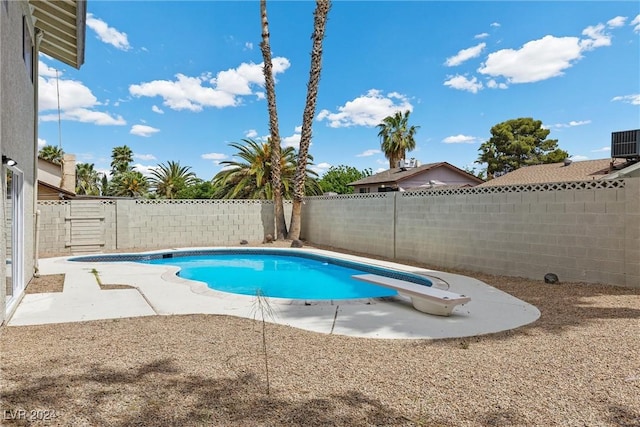 view of swimming pool featuring a diving board