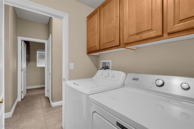 laundry room featuring cabinets, washing machine and clothes dryer, and light tile patterned flooring