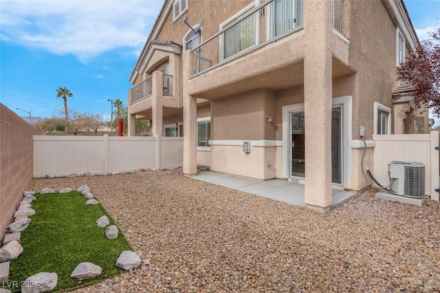 view of yard featuring central AC, a balcony, and a patio