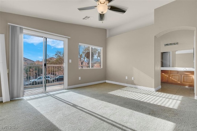 spare room with ceiling fan and light colored carpet